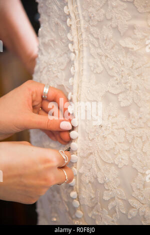 Close up of wedding dress being done up on the brides wedding day Stock Photo