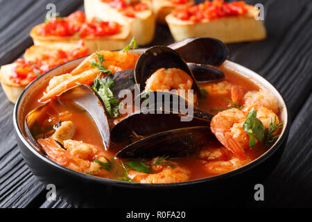 French seafood bouillabaisse soup closeup in a bowl served with toast on the table. horizontal Stock Photo