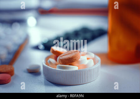 Close-up view on the pills in bottle's cap laying on the table Stock Photo
