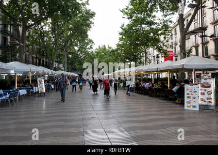 People walking along La Rambla passing several restaurants, Barcelona, Spain Stock Photo