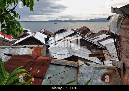 Ramshackle hamlet of wooden and bamboo huts on stilts over the water with tin roofs and streets as precarious bridges of timber planks-Badjao people's Stock Photo