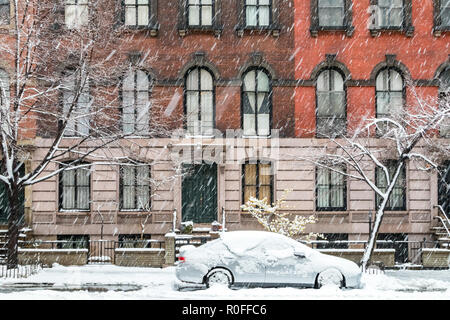 New York City winter street scene with snow covered car parked on Stuyvesant Street in the East Village of Manhattan Stock Photo