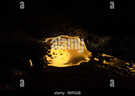 liquid gold is spilled in a dark room Stock Photo
