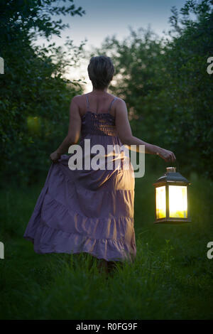 Woman with lantern in the middle of the night Stock Photo