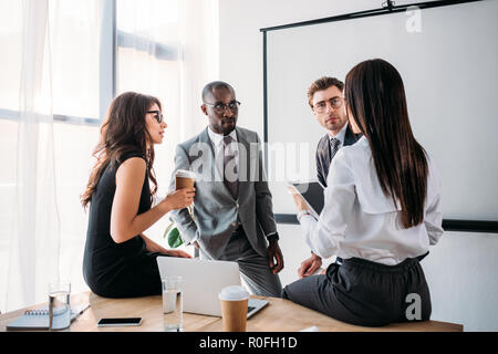 group of multiracial business coworkers in formal wear discussing new business plan in office Stock Photo