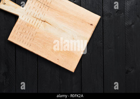 Top view of new handmade chopping board on black wooden table with copy space. Stock Photo