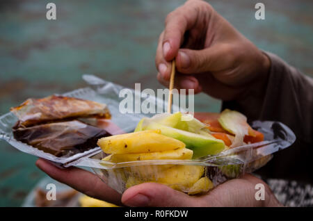 RUJAK - hand picking fruits from traditional fruit and vegetable salad in Indonesia Stock Photo