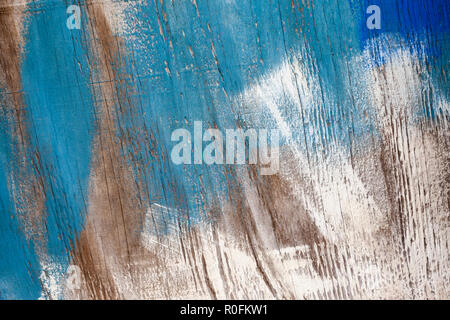 Blue and white brush strokes on a piece of plywood, where someone has tried to wipe the excess paint off their brush, but has created abstract art Stock Photo