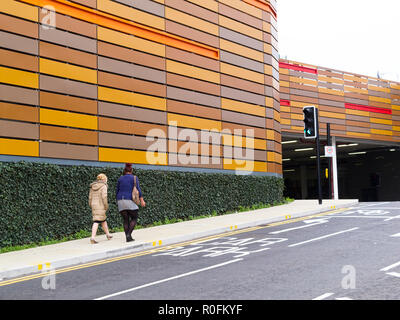 Two young women walking towards the entrance to the indoor car park beneath the Tesco Extra store Trinity Square Gateshead, Tyne and Wear UK Stock Photo