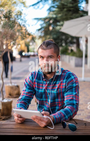 Handsome hipster guy working on digital tablet. Stock Photo