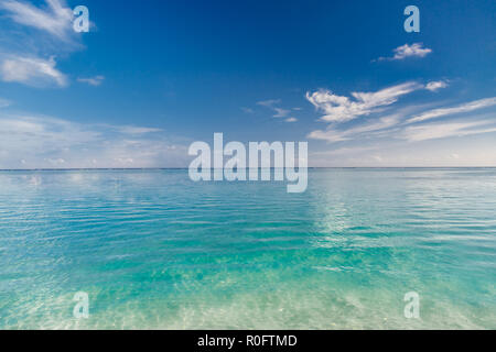 Beach and beautiful tropical sea. Caribbean or Maldives summer sea with blue water. White clouds on a blue sky over summer sea. Relaxing tropical sea Stock Photo