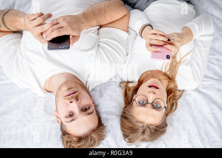 surprised young couple with mobile phones Stock Photo