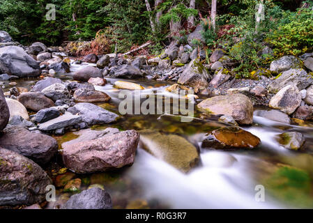 Long Exposure of a lush mountain river at twilight. Shot in the Pacific Northwest during autumn. Stock Photo