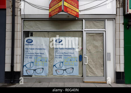 Empty shop on high street, Boots opticians, we have moved location posters, in window, shop facade in cleveleys lancashire uk Stock Photo