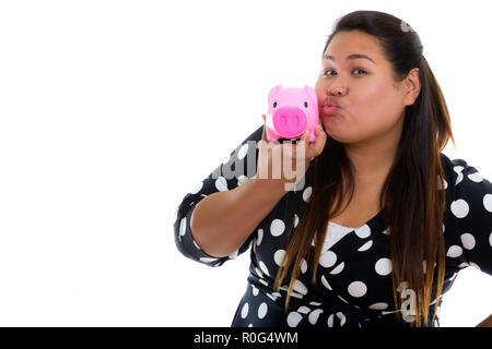 Studio shot of young fat Asian woman puckering lips and holding  Stock Photo