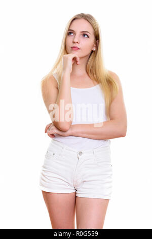 Studio shot of young beautiful teenage girl standing while think Stock Photo