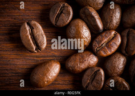 fresh roasted coffee beans macro close up on natural dark oak wood background Stock Photo