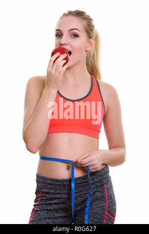 Studio shot of young beautiful teenage girl eating red apple and Stock Photo