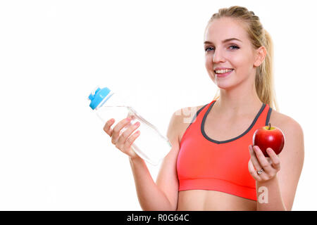 Young happy teenage girl smiling while holding water bottle and  Stock Photo