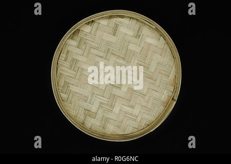 Round bamboo plate isolated on black background Stock Photo