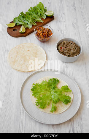 Making shrimp tacos on white wooden background, high angle view. Mexican kitchen. Stock Photo