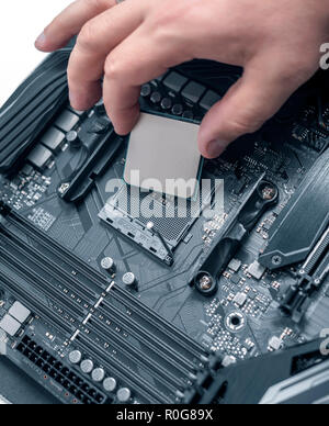 Installing processor unit into computer motherboard. Stock Photo