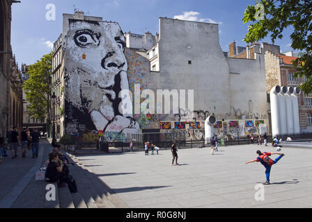 Men kick a soccer ball and children play on a plaza near the Centre Georges Pompidou (Pompidou Center), a high-tech style multicultural complex, Paris Stock Photo
