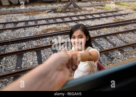 Beautiful woman holding hand of man passanger in train Stock Photo