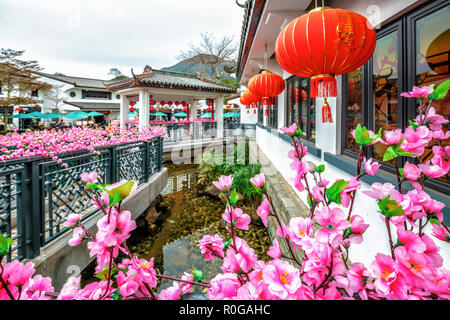 Hong Kong, China - January 26, 2016: Tea House exterior in Ngong Ping 360 village on Lantau Island decorated with blooming sakura branches and red fes Stock Photo