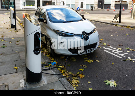 White Renault Zoe Dynamique NAV electric car charging at kerbside charging point. Stock Photo
