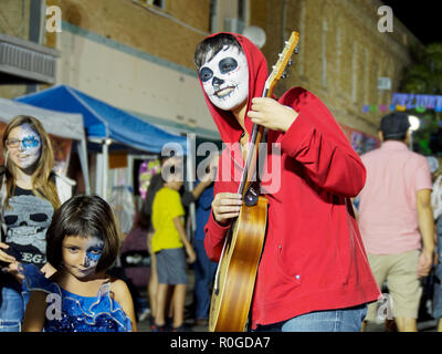 A guitar player in face paint and red hooded jacket at the 2018 Dia De Los Muertos or, Day Of The Dead, celebration in Corpus Christi, Texas USA. Stock Photo