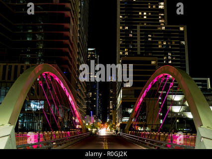 A new suspension bridge spanning shoal creek on 2nd street of downtown Austin, Texas flashes multiple bright colors at night. Stock Photo