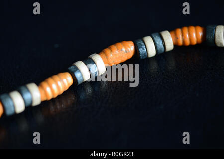 Fragment of a wooden necklace on a dark background close up Stock Photo
