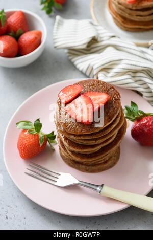 Chocolate pancakes with strawberries on pink plate, high angle view Stock Photo