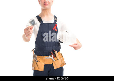 cropped image of worker in uniform and red ribbon holding helmet and condom isolated on white, world aids day concept Stock Photo