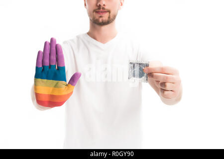 cropped image of homosexual man with hand painted in rainbow holding condom isolated on white, world aids day concept Stock Photo