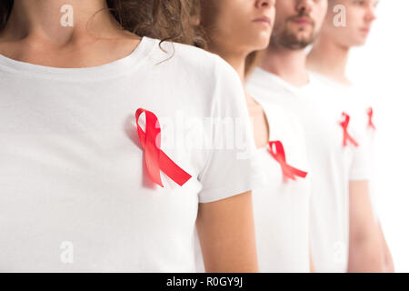 cropped image of people standing with red ribbons on white shirts isolated on white, world aids day concept Stock Photo