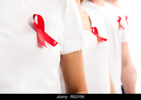 selective focus of people standing with red ribbons on shirts isolated on white, world aids day concept Stock Photo