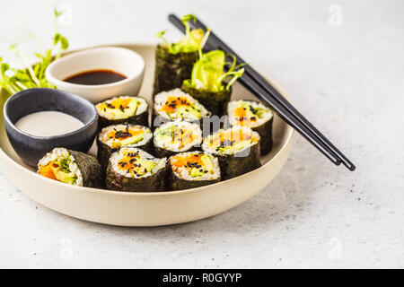 Vegan sushi rolls with pumpkin, brown rice and avocado. Plant based diet food.