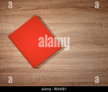 Red book on dark brown wooden table Stock Photo