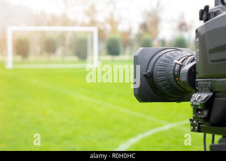 video camera put on the back of football goal for broadcast on TV sport channel. football program can't editing in studio. camera man is importance to Stock Photo