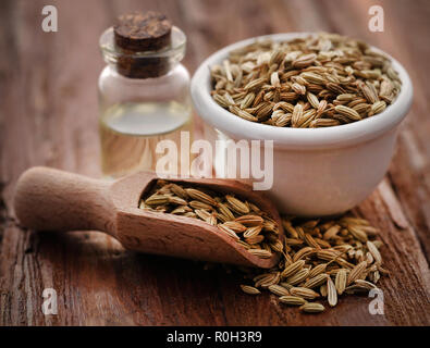 Fennel seeds with essential oil in a bottle on natural surface Stock Photo