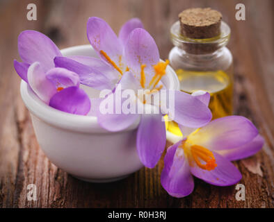 Saffron crocus flower with extract in a bottle on natural surface Stock Photo