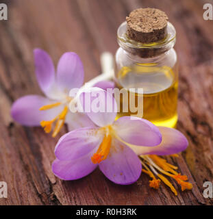 Saffron crocus flower with extract in a bottle on natural surface Stock Photo