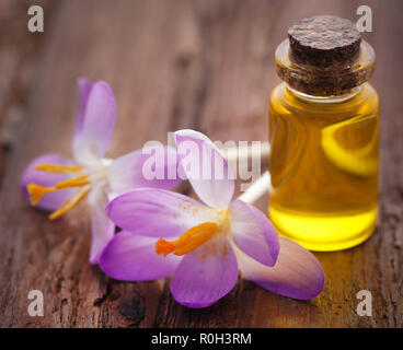 Saffron crocus flower with extract in a bottle on natural surface Stock Photo