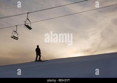 Skier silhouette against glowing sky Stock Photo