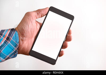 Hands of a man in blue plaid shirt using a mobile phone isolated white. Horizontal composition Stock Photo