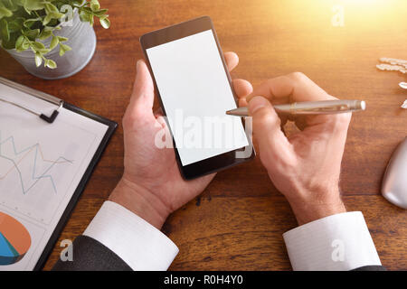 Businessman working with a smartphone on brown wood table in the office. Horizontal composition. Top view Stock Photo