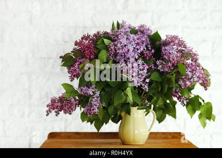 Lilac flower in a vase on a wooden background Stock Photo