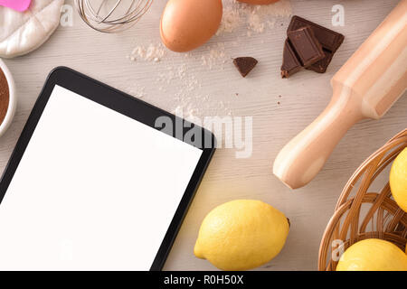 Pastry ingredients on a white wooden table and tablet Concept of recipes in digital book. Horizontal composition. Top view Stock Photo